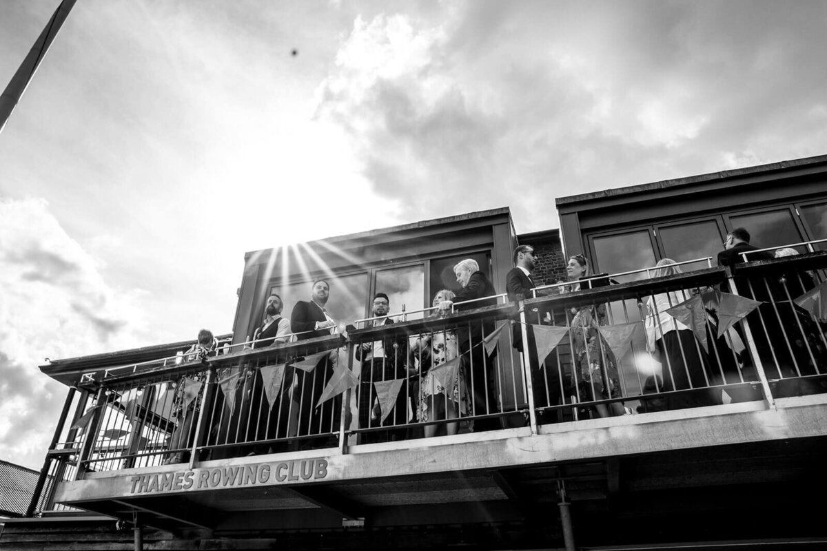 Wedding guests standing on Thames Rowing Club balcony