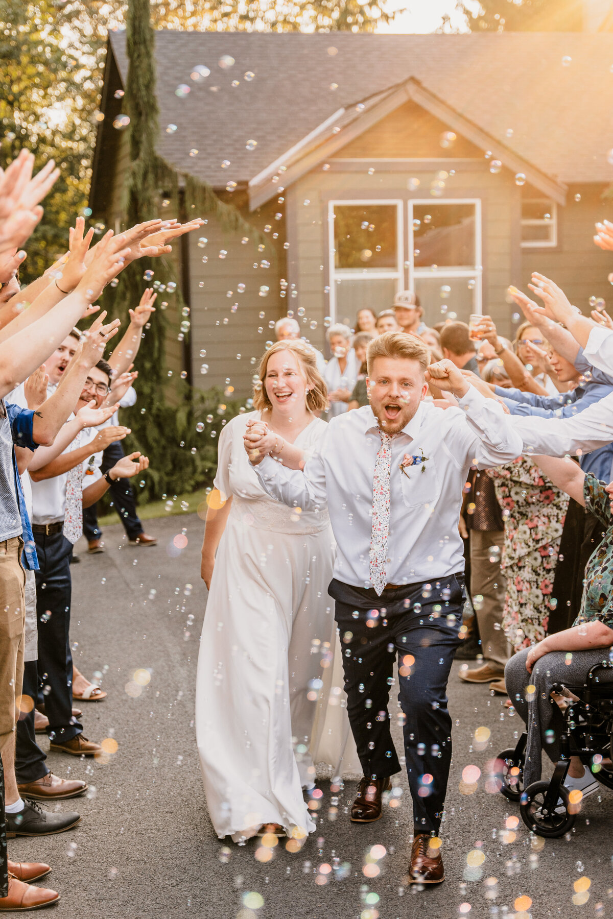 The bride and groom run through a tunnel of bubbles as they exit their wedding.