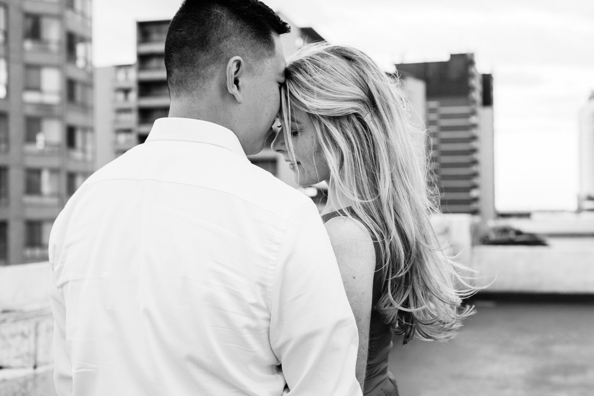 Guy-rests-his-head-on-his-fiances-forehead-as-they-close-their-eyes-and-enjoy-being-together-on-a-rooftop-in-windsor-ontario