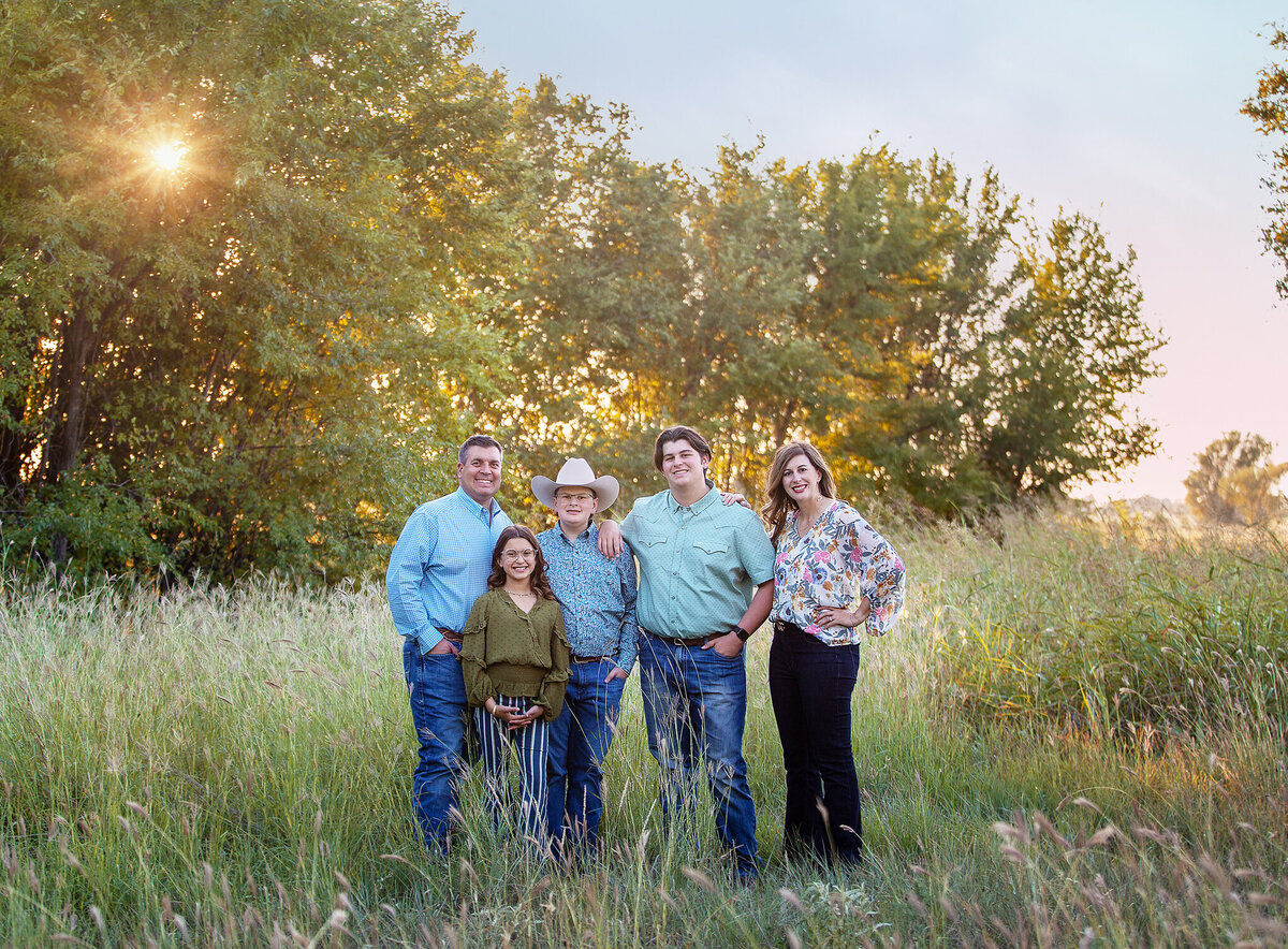family standing in green field and trees swisher co