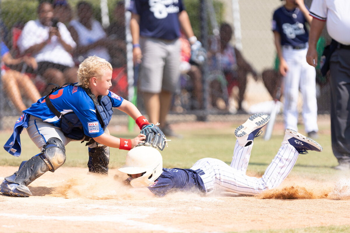 A Team Georgia player tags a team South Carolina player out at home plate during the Dixie Youth League World Series 2023.