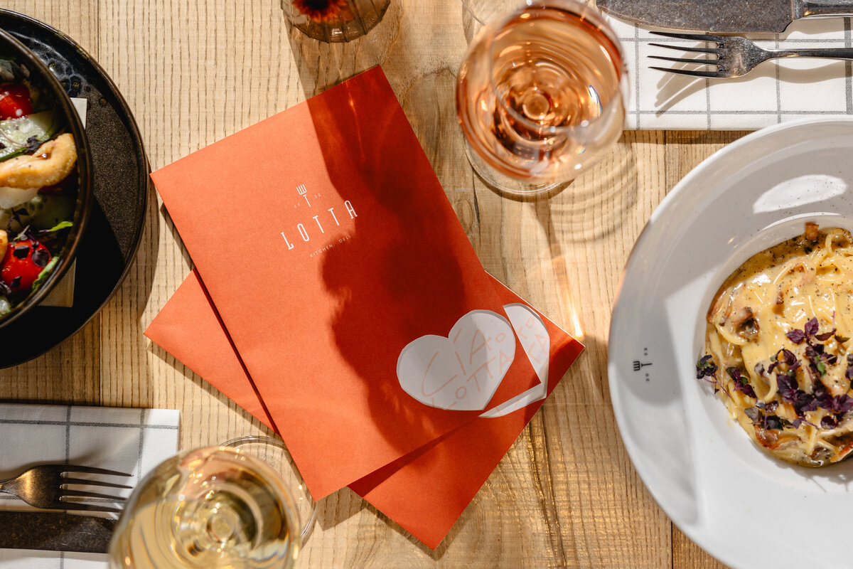 Menükarte und Glas Wein im Restaurant LOTTA.