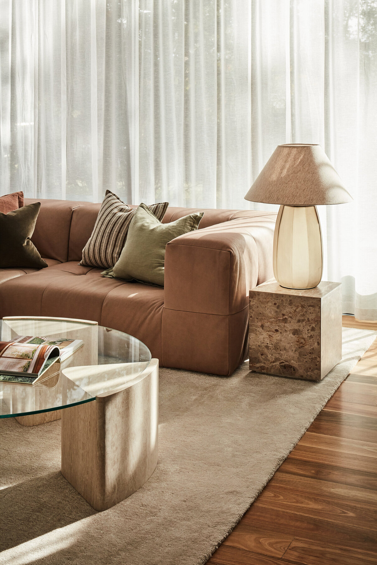 Melbourne interior designer living room project with brown sofa, marble side table, and glass coffee table.