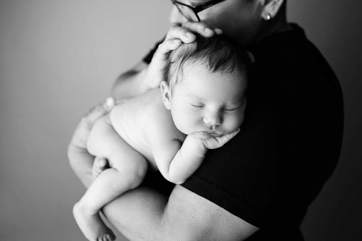 black and white image of mom and newborn baby snuggled