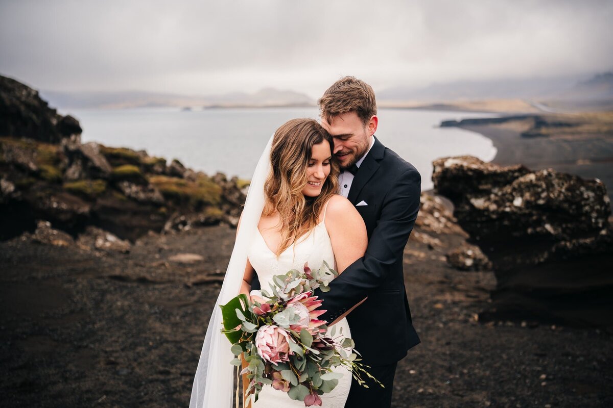 Capturing the essence of their Iceland elopement, the groom stands behind the bride in this portrait, creating a beautiful and intimate moment.