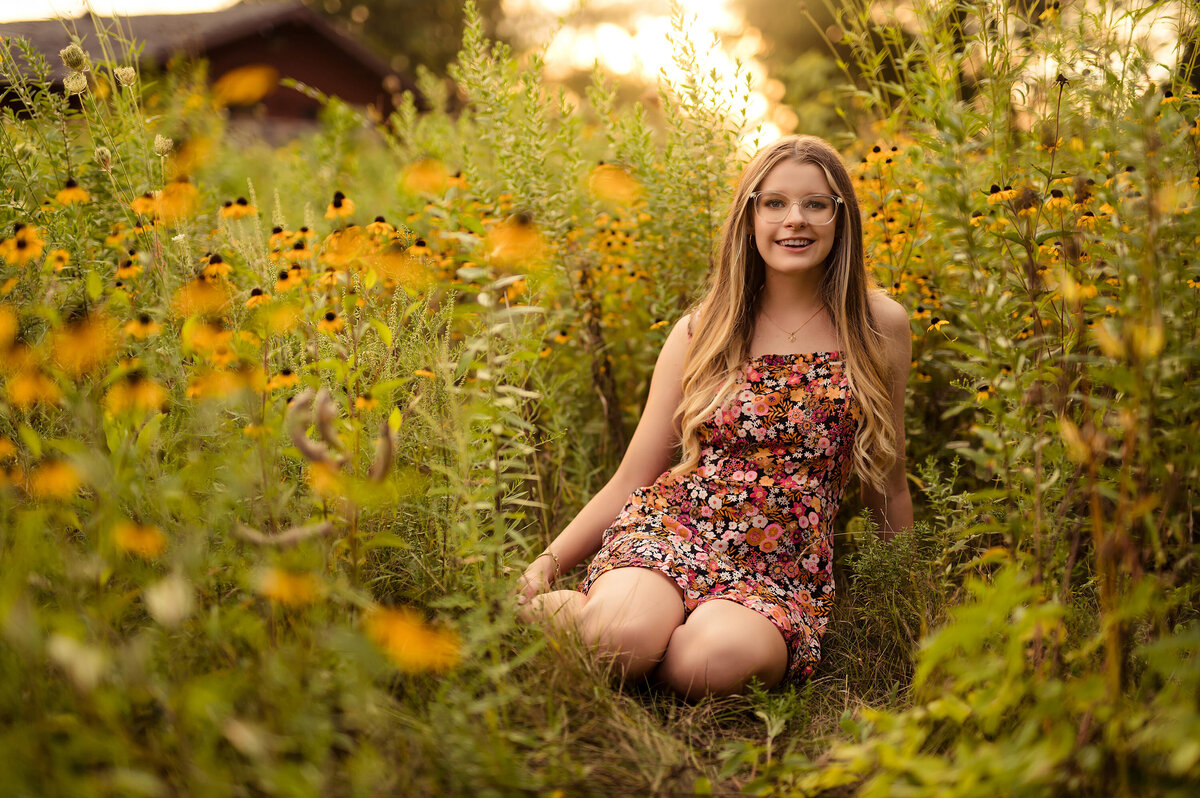 A girl from Germantown High School sits in a field of Black Eyed Susan Flowers in Waukesha's Minooka Park.