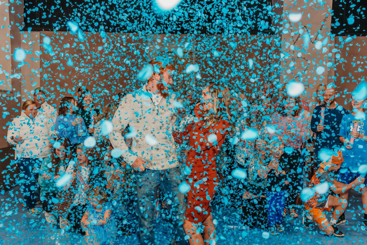 photo of Allie and her husband surrounding by blue confetti
