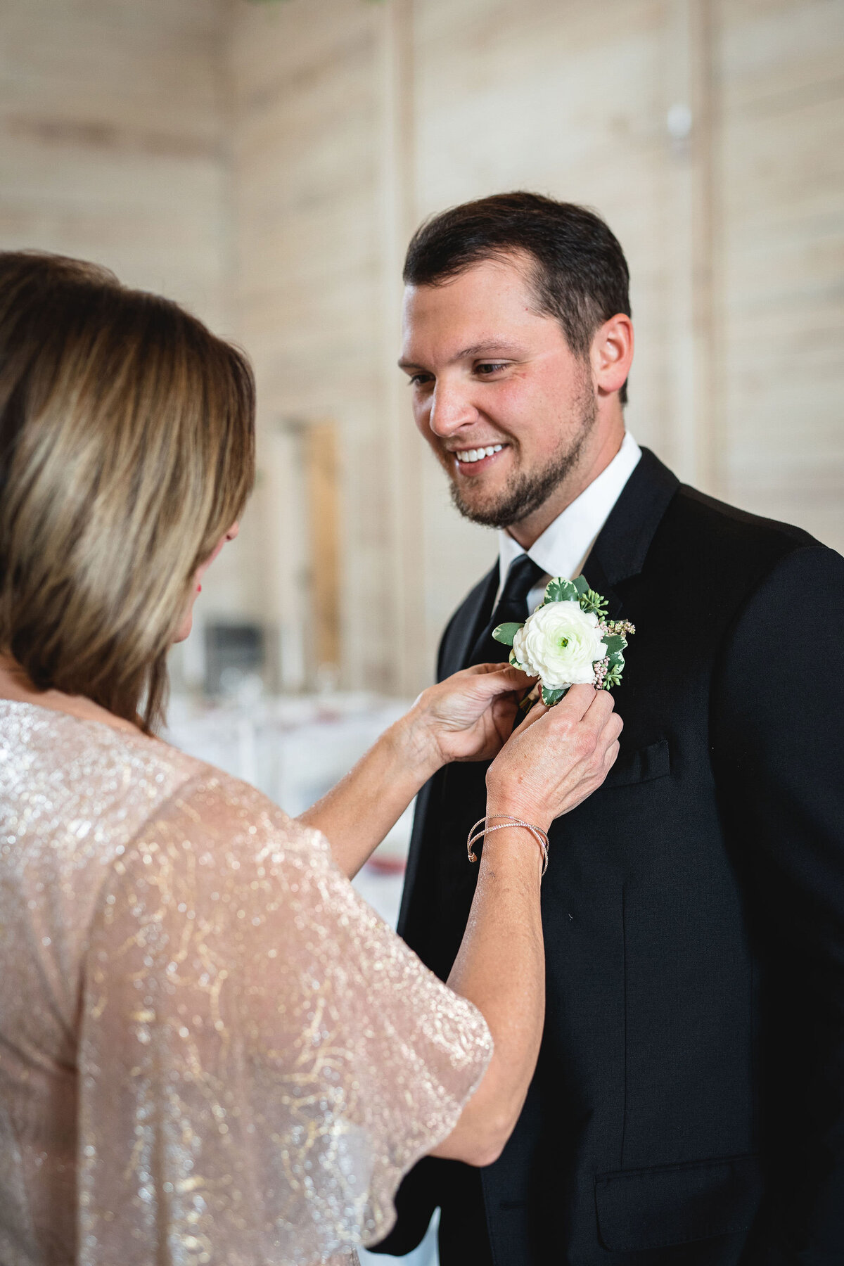 Mother of the groom pinning grooms boutonniere
