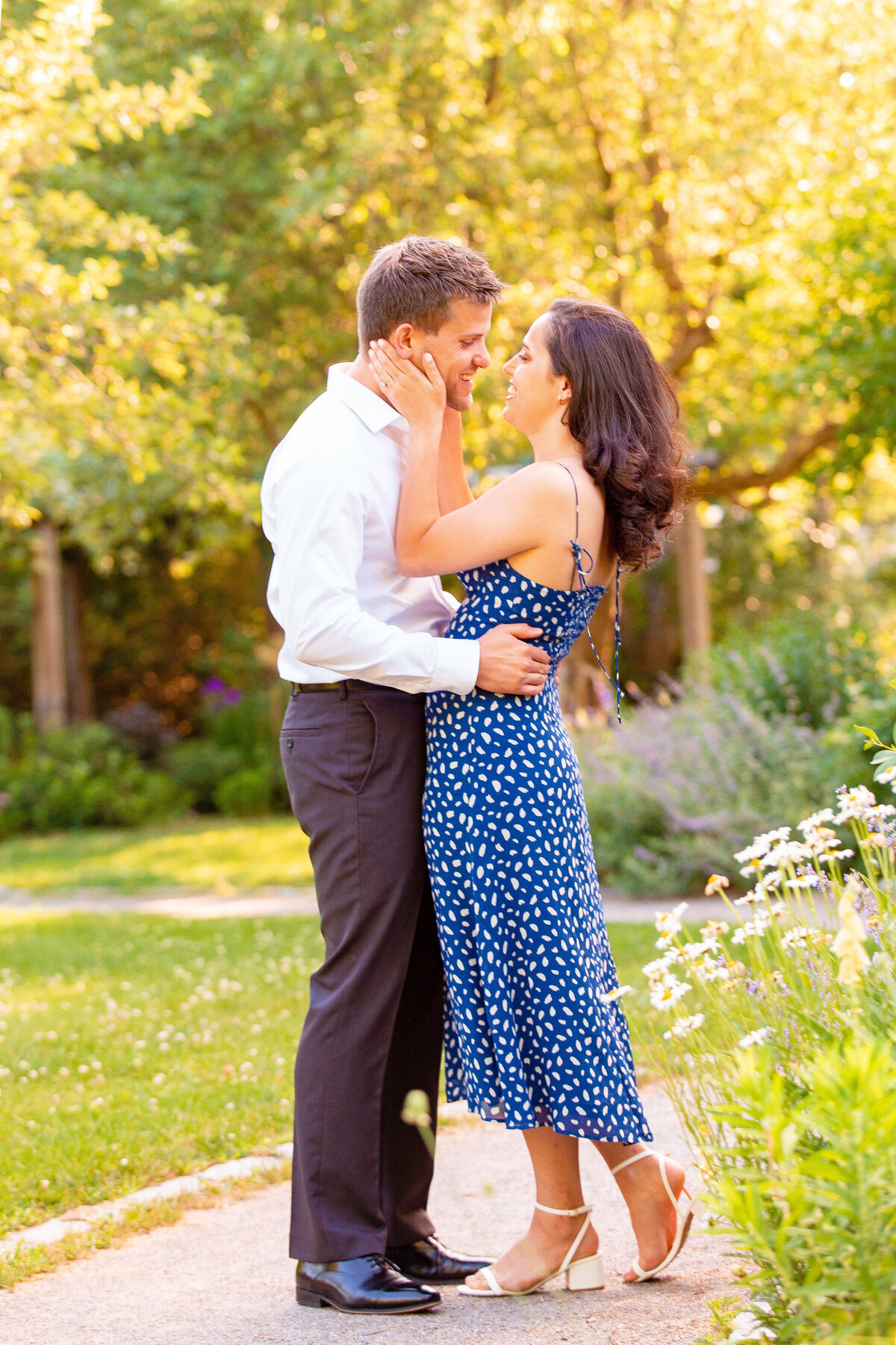 Man and woman laugh as they embrace during their engagement session.