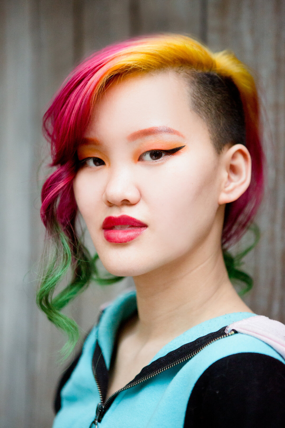 Asian-American teenage girl with rainbow colored dyed hair poses outside Nyack High School senior portrait photographer Milestone Images