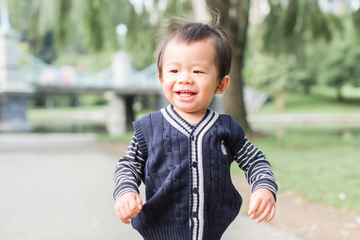 Boy smiling and running through the Boston Public Garden