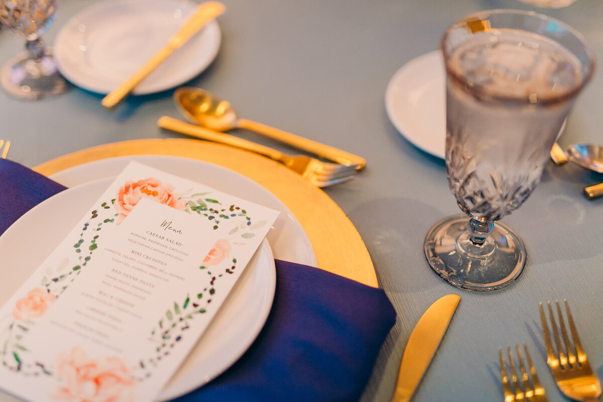 Details of a mitzvah reception table set up with gold silverware