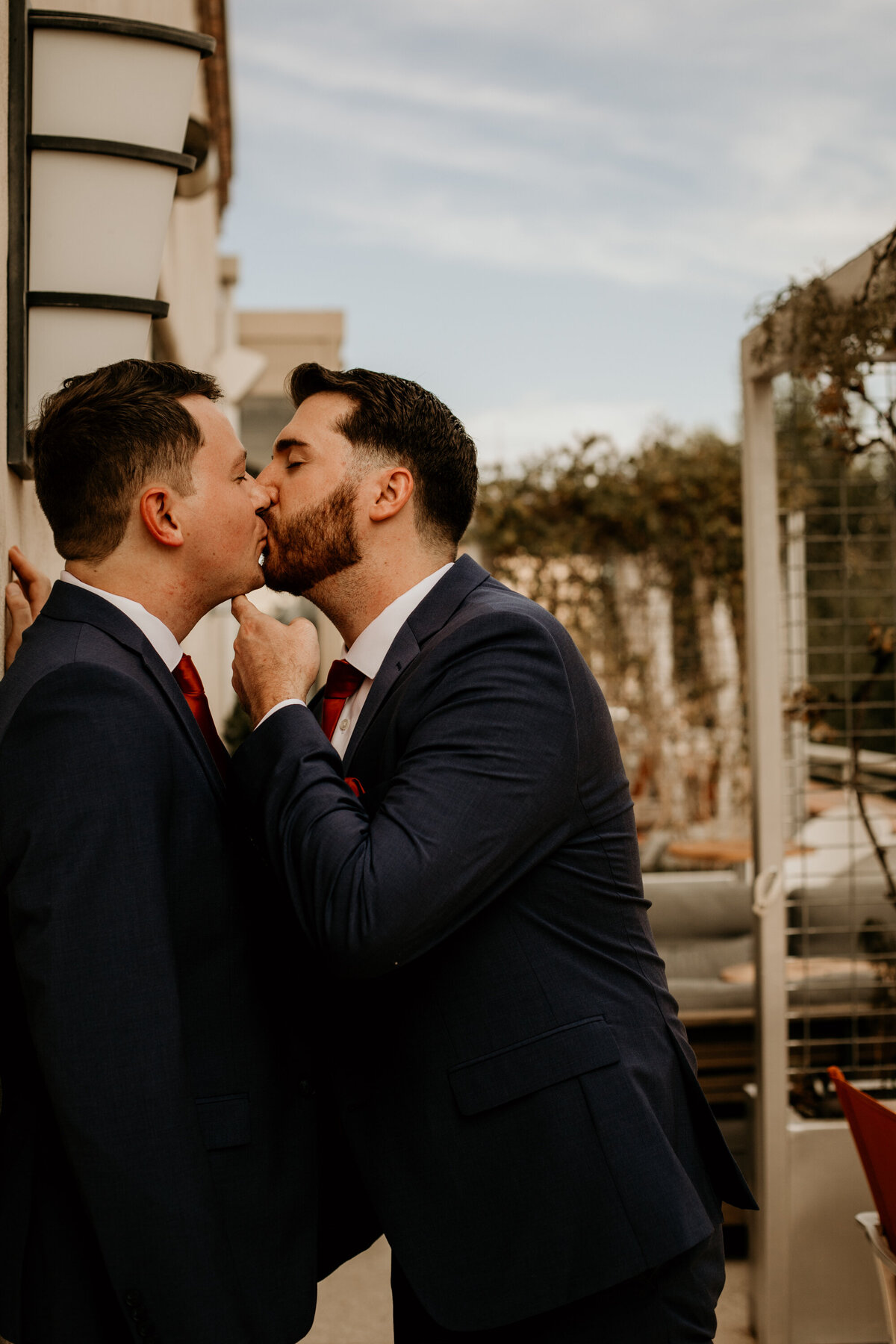 two grooms kissing on a balcony in downtown Albuquerque