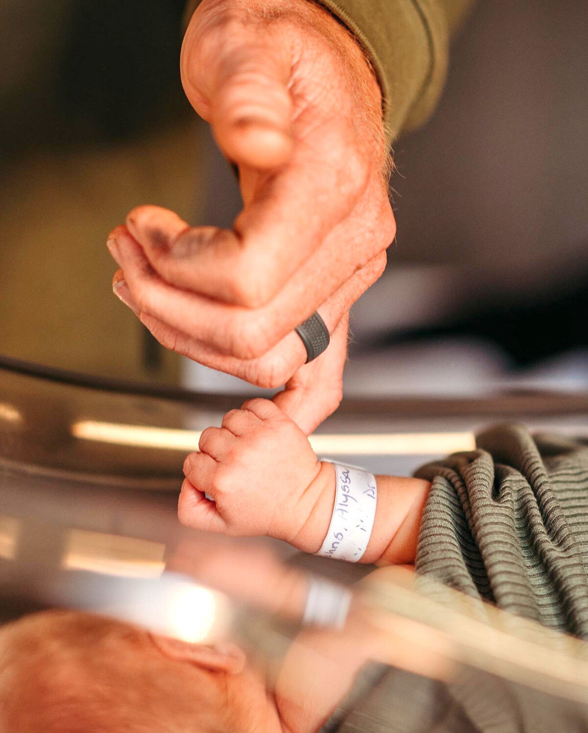 photo of a baby holding Tyler's pinky finger