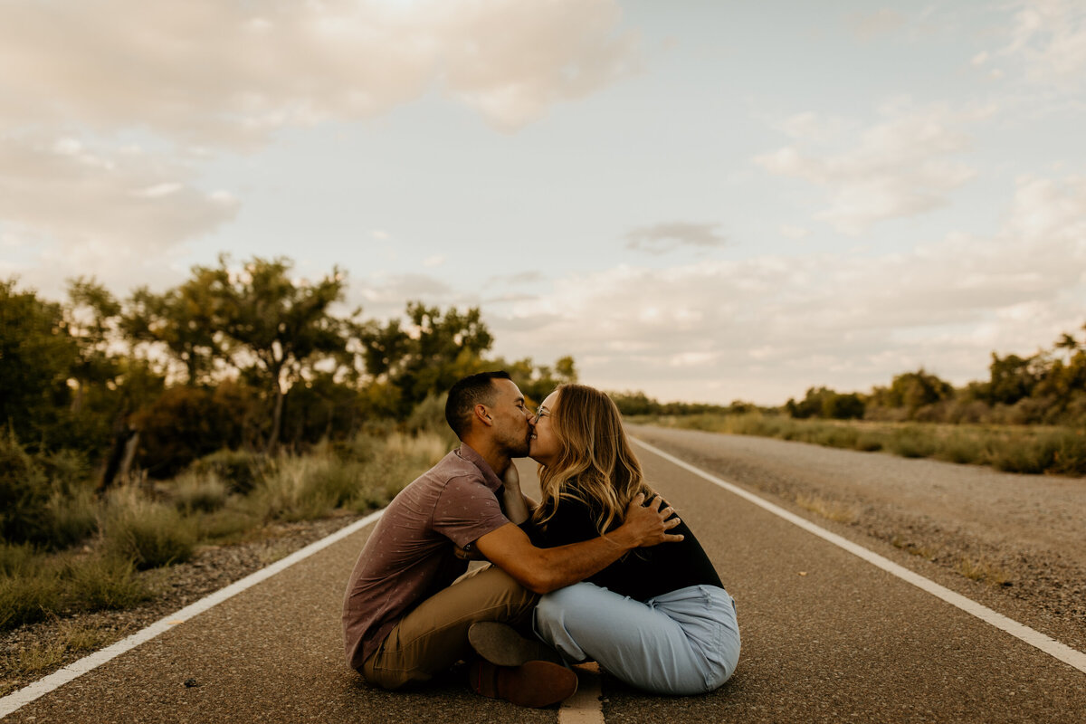 engaged couple kissing on a bike trail in Albuquerque