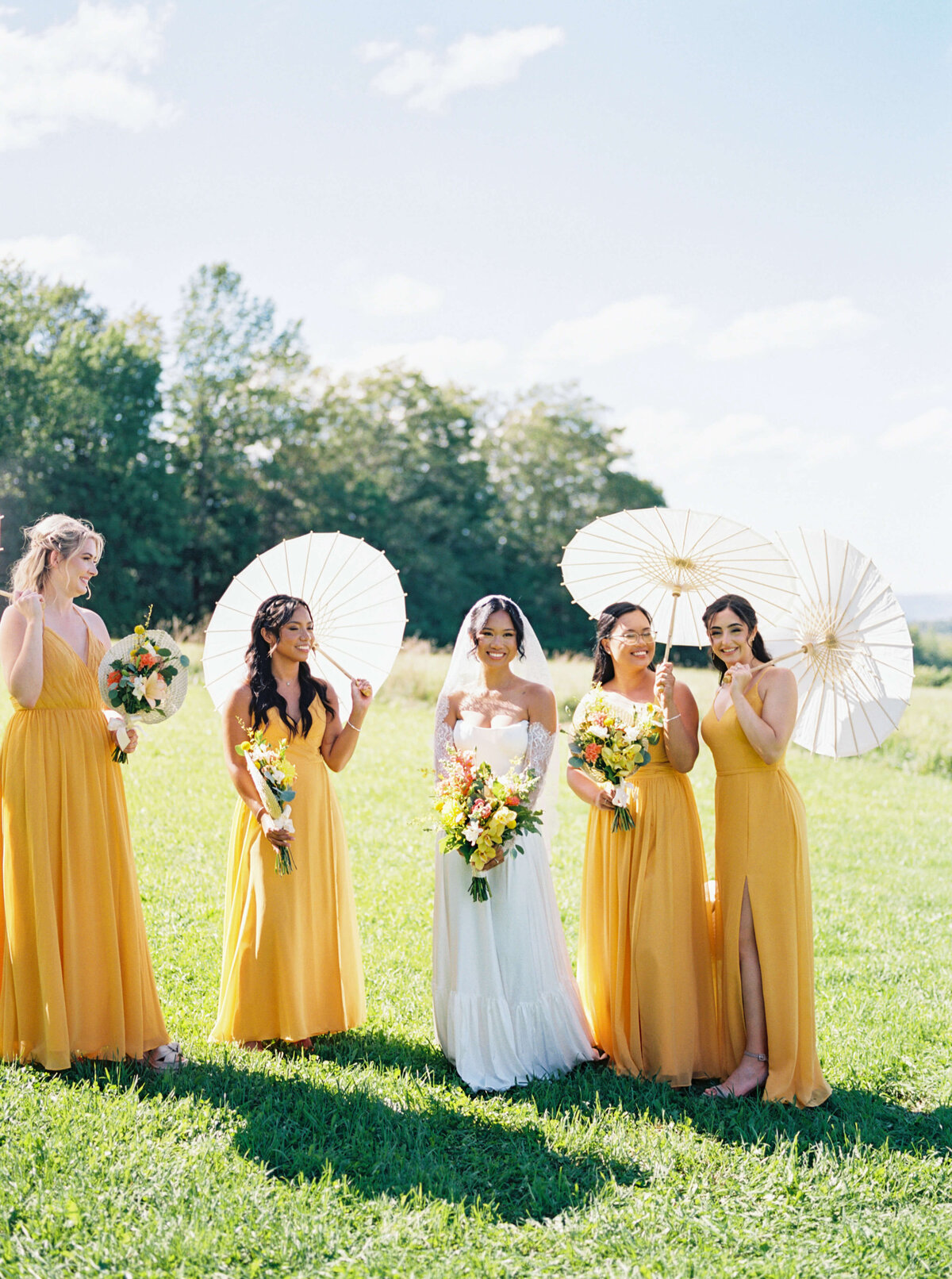 Bride with bridesmaids wearing yellow dresses and sunshades at  Woodburn Ridge Wedding, Nova Scotia