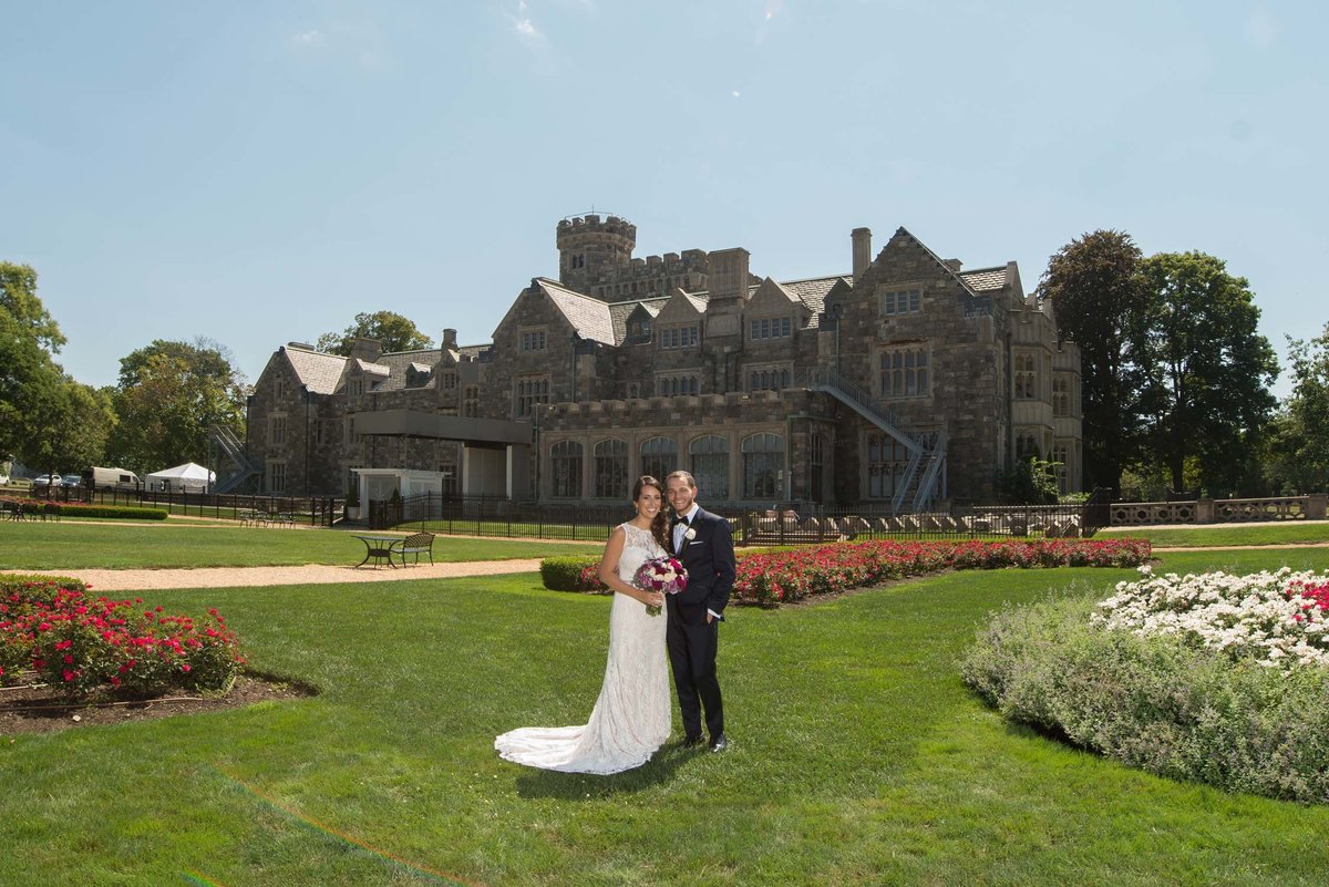 Bride and groom posing in front of Hempstead House