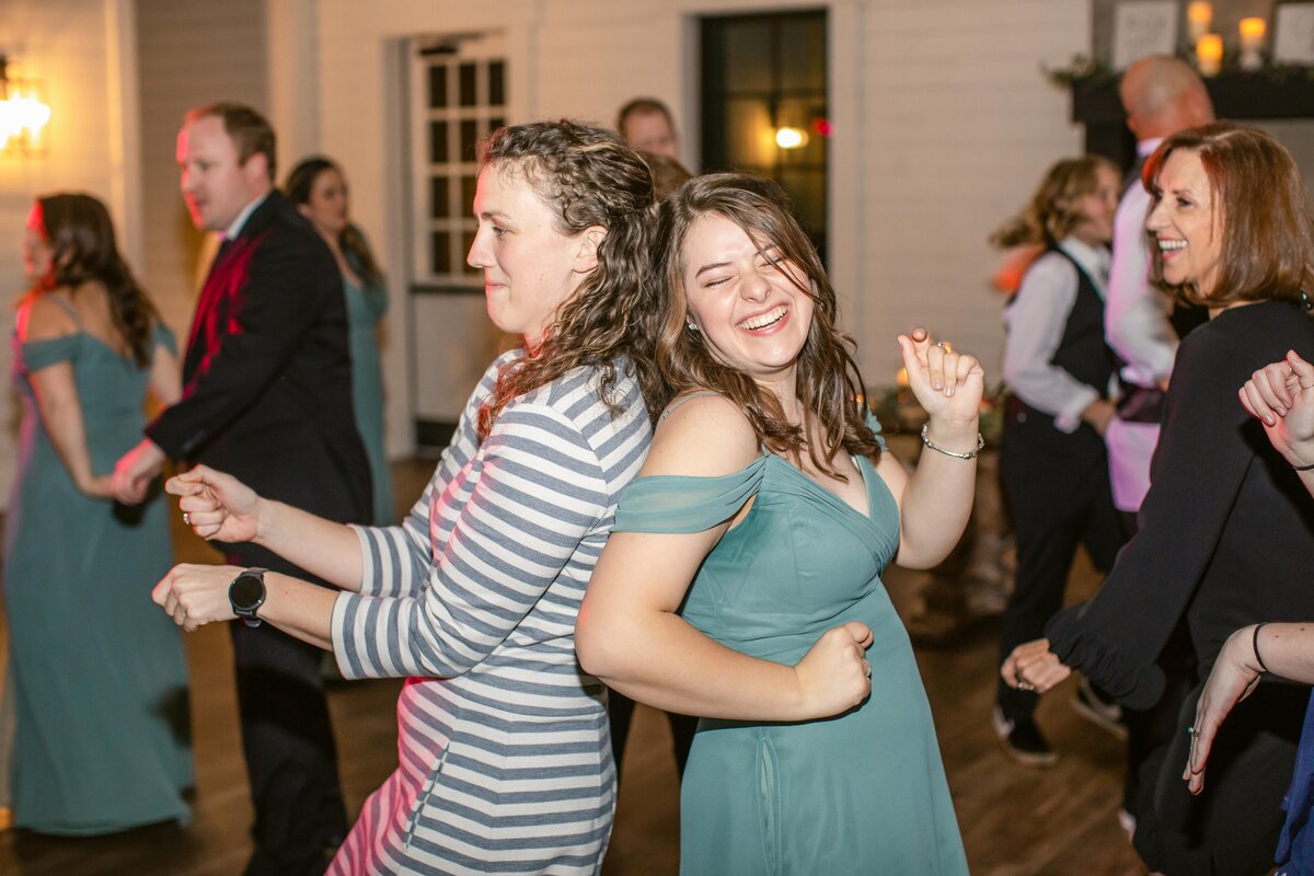 two women dance during wedding reception  at Morgan Creek Barn in Dripping Springs