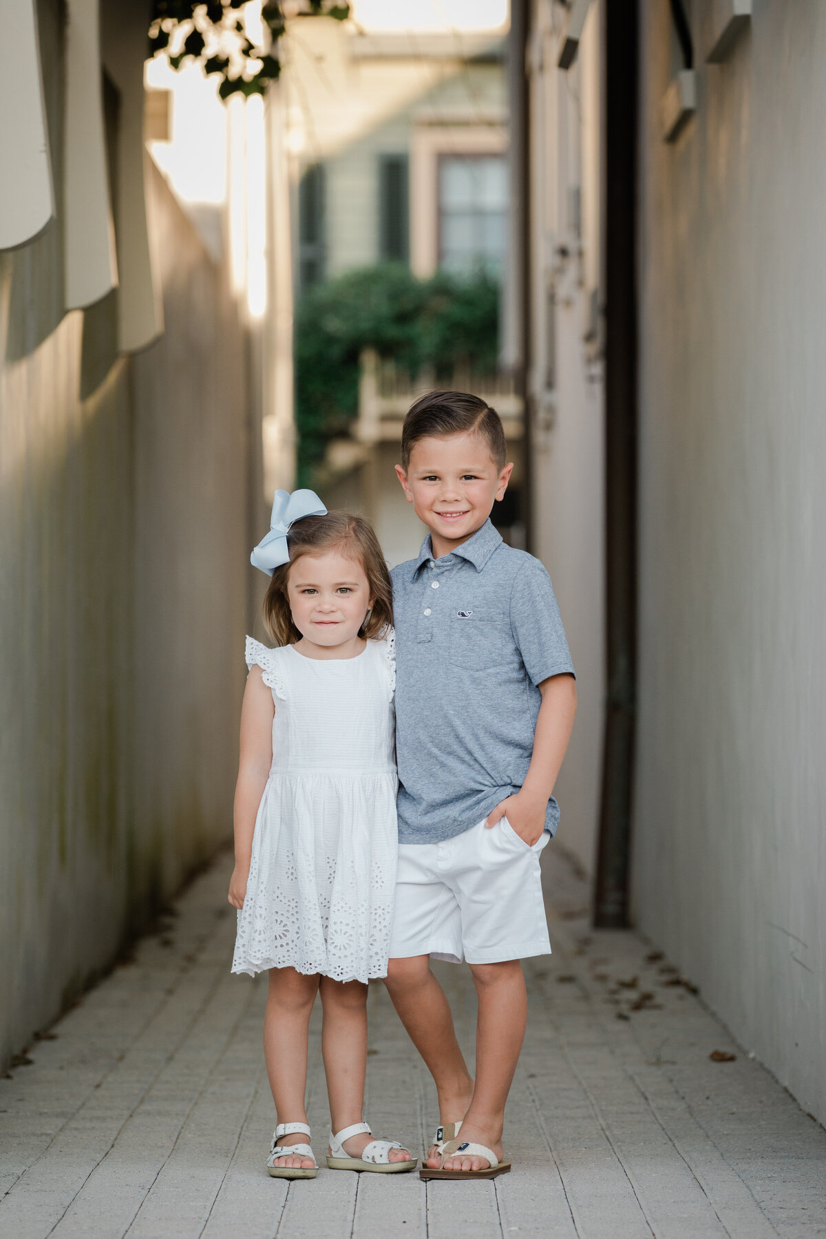 Two small kids with their arms around each other smiling