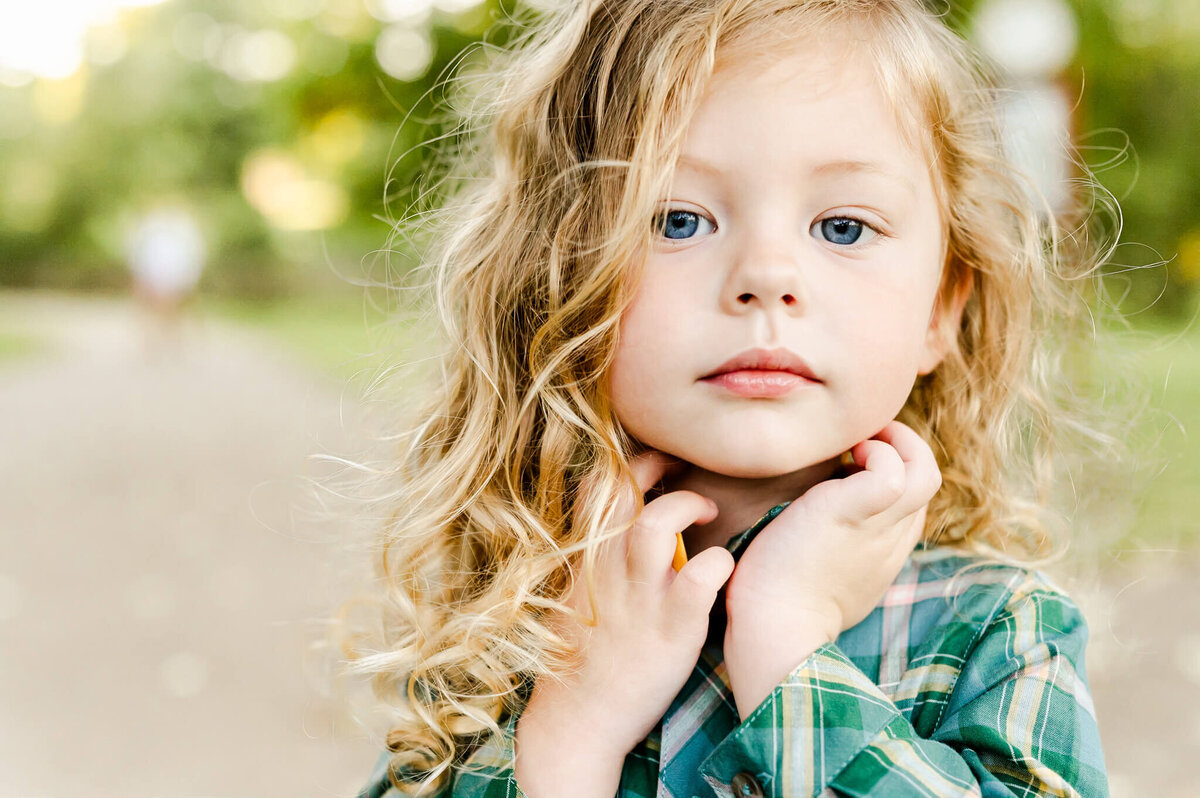 Close up of serious toddler staring into camera at family session near Chicago, IL.