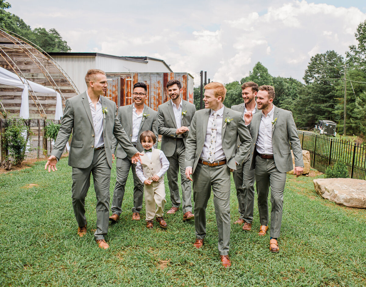groomsmen walking together at summer wedding