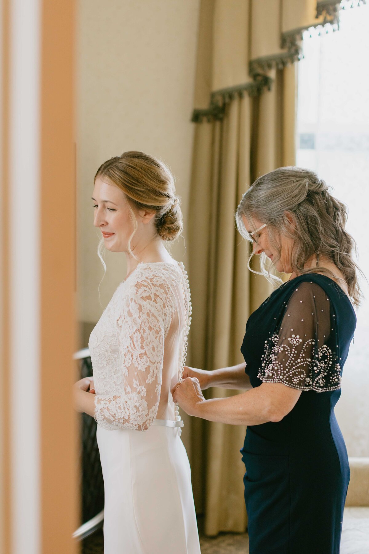 bride putting on dress for wedding day