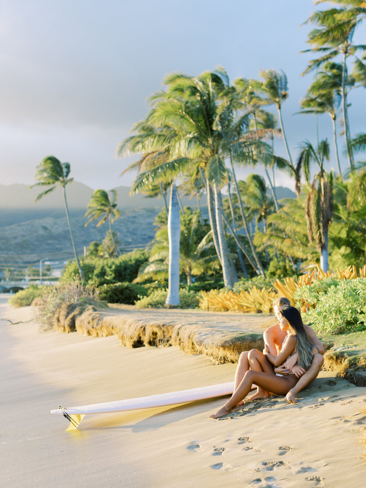 couple-on-oahu-beach-with-surfboard