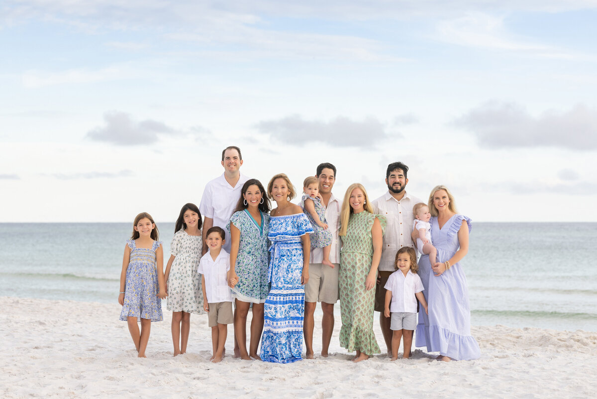 An extended family smiling together at the beach