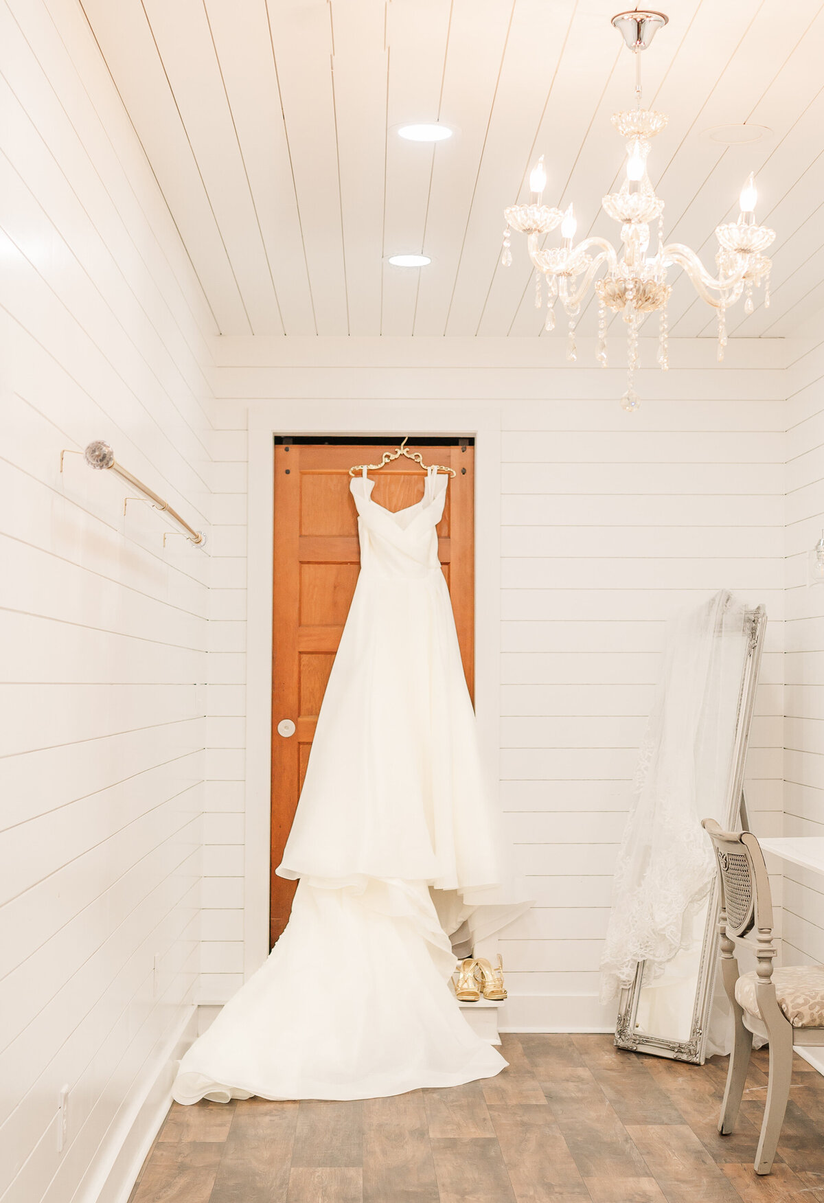 A wedding dress hanging in a bridal suite at The Peanut Warehouse by Raleigh wedding photographer, JoLynn Photography
