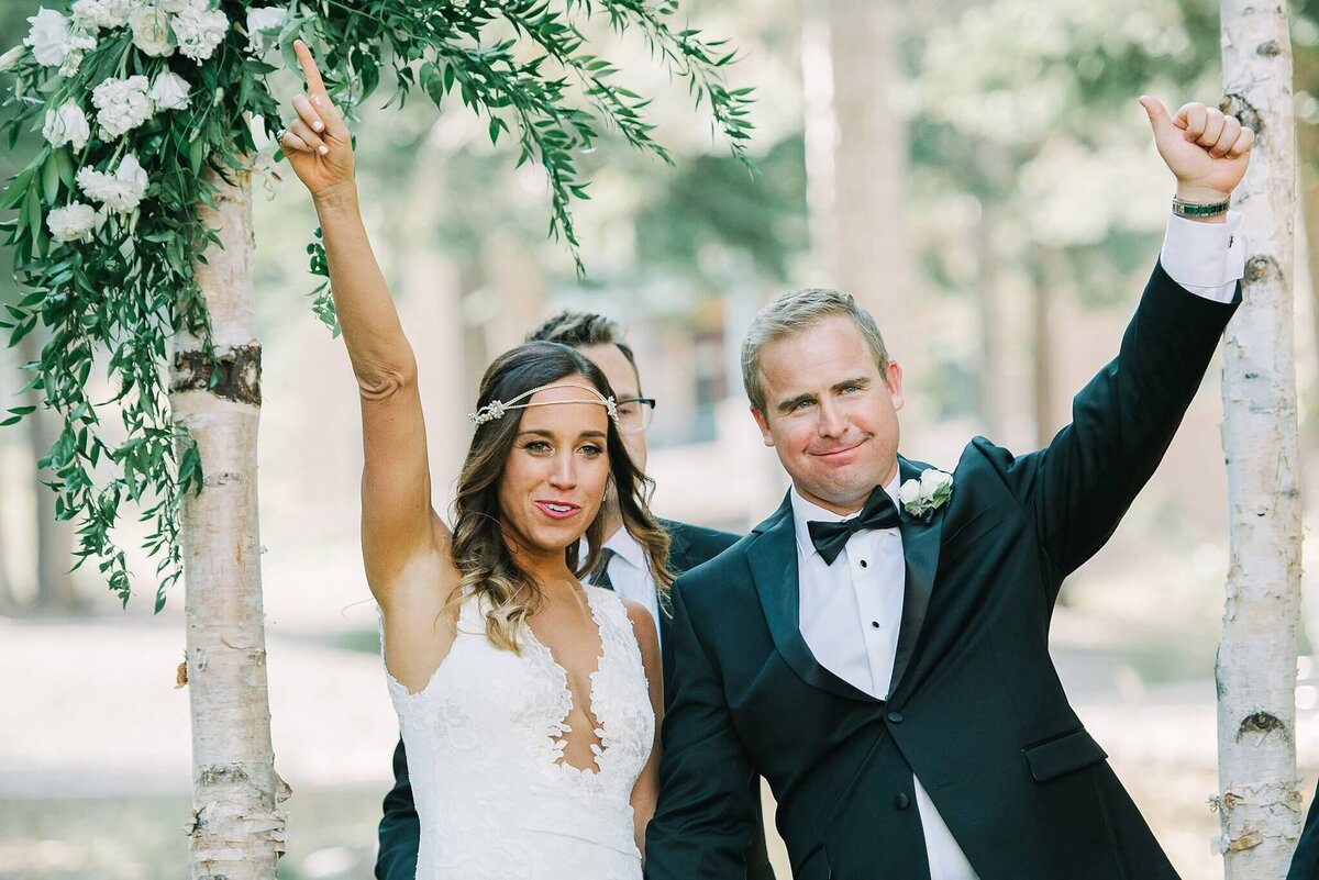 Ritz tahoe Just married couple arms in the air down the aisle