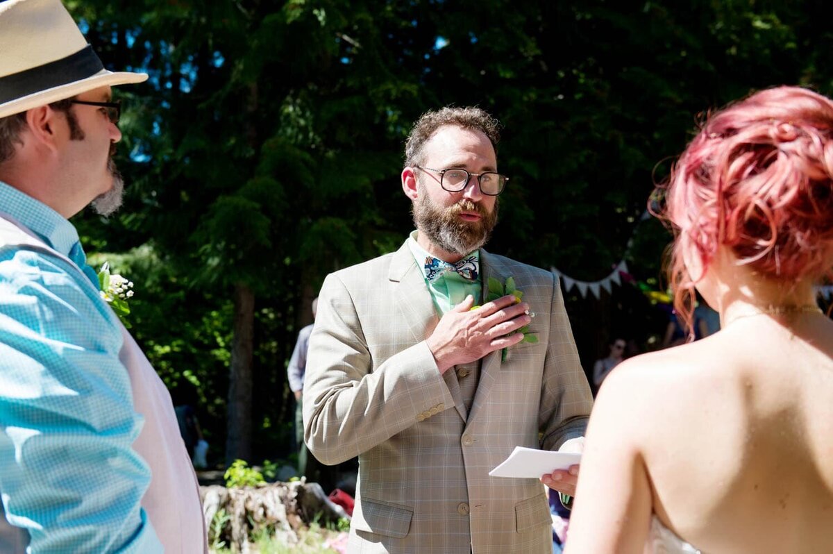 a groom touches his heart during his wedding vows