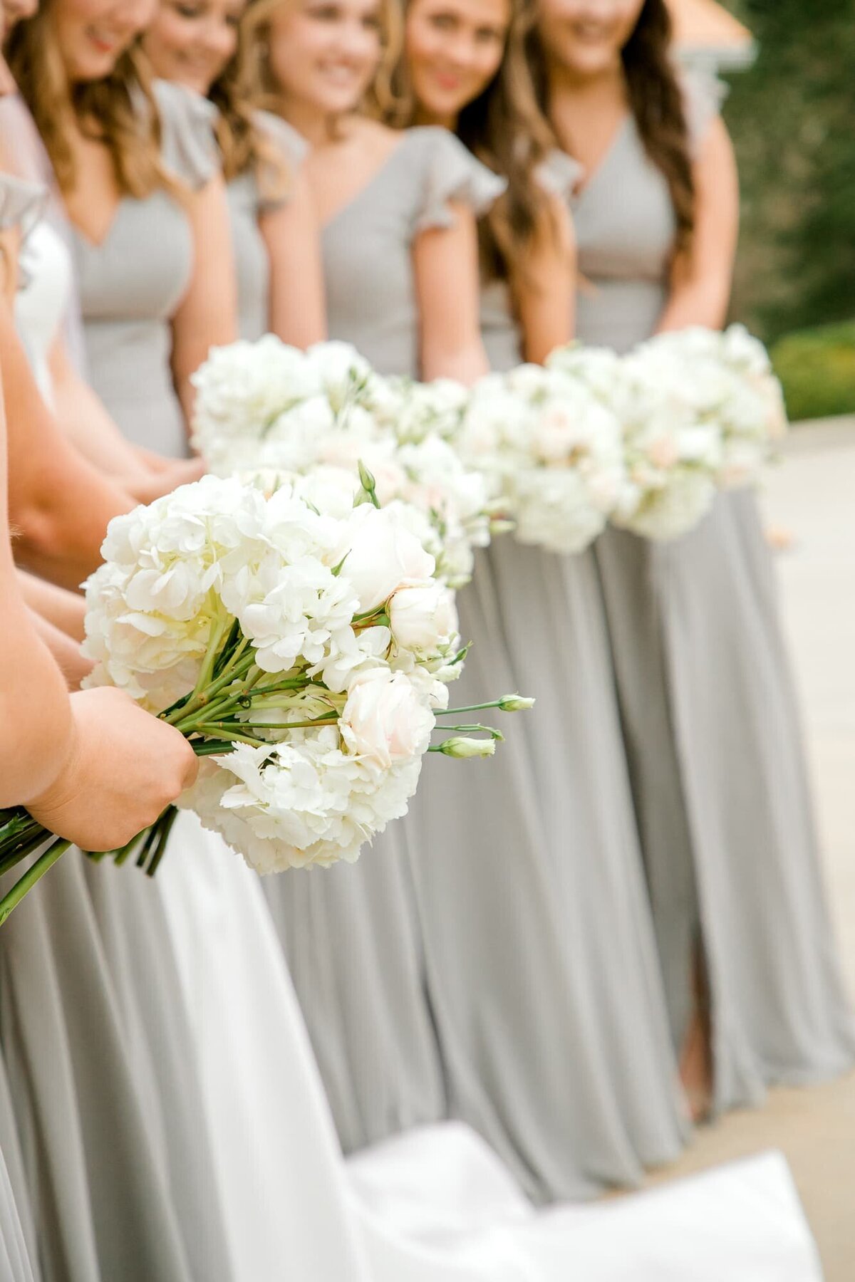 Bridesmaids in gray dresses with white bouquets