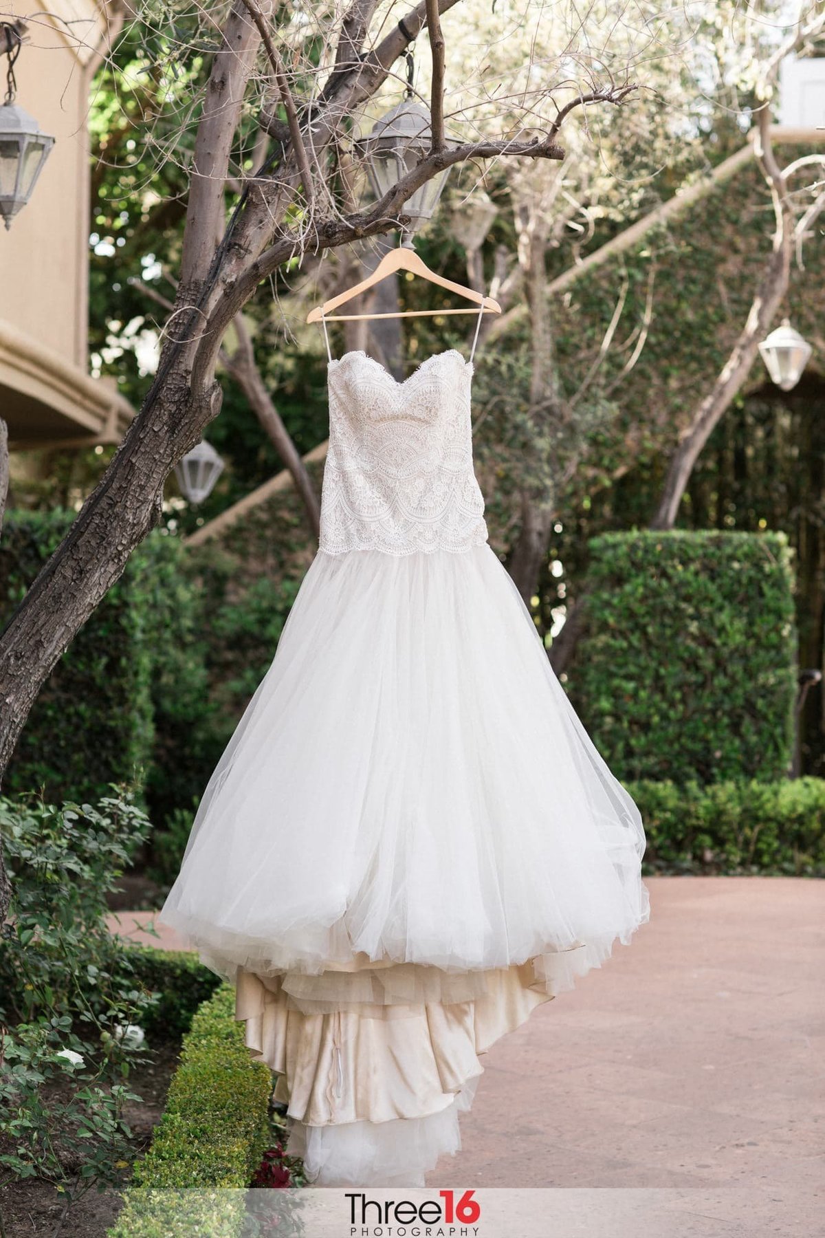 Bride's white dress hangs on display