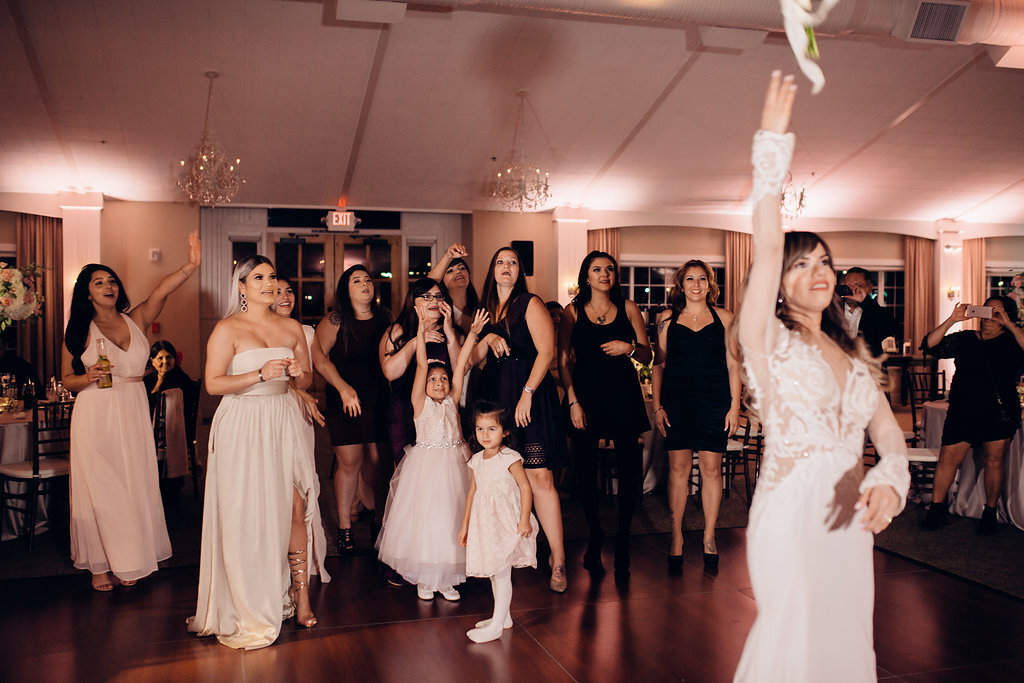 Wedding Photograph Of Women In White And Maroon Dresses Preparing To Catch The Bouquet Thrown By The Bride Los Angeles