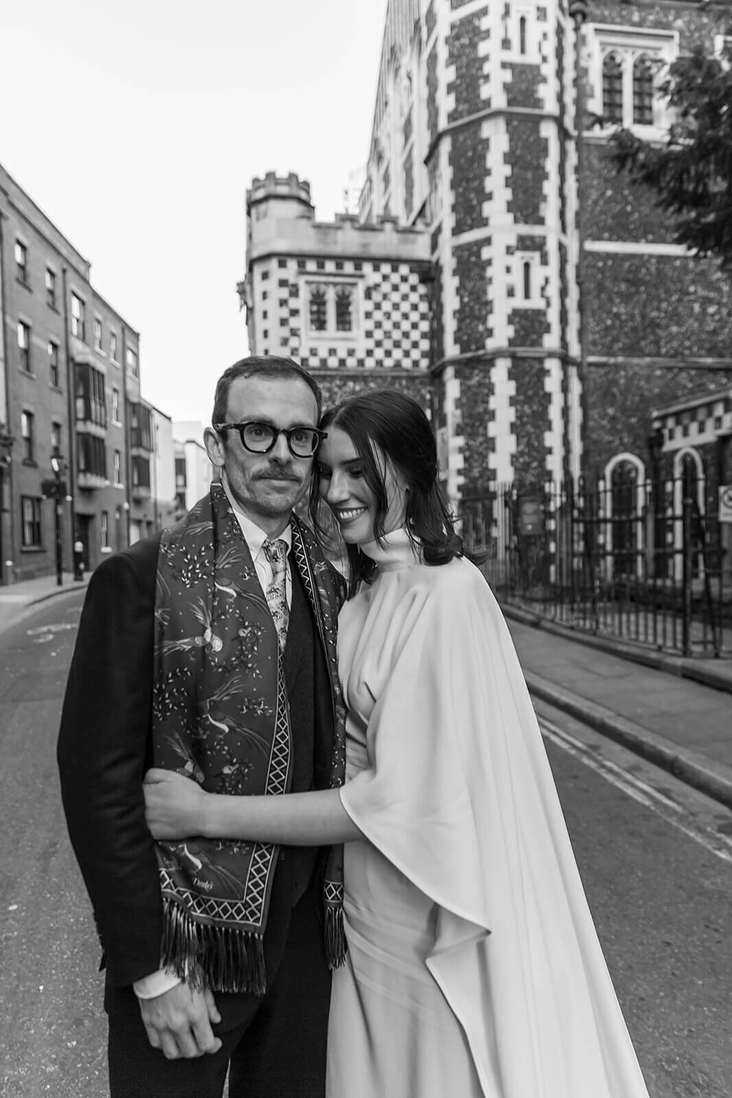 Hipster bride and groom on streets of london hugging