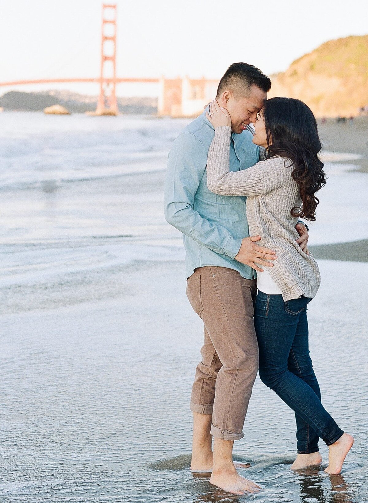 San Francisco engagement photographer Robin Jolin captures a newly engaged couple at the Baker Beach with the Golden Gate Bride in the backdrop.