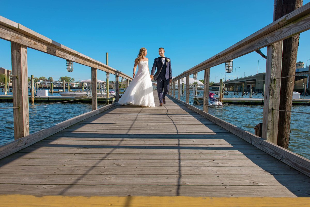 Bride and groom walking down the pier at Bridgeview Yacht Club