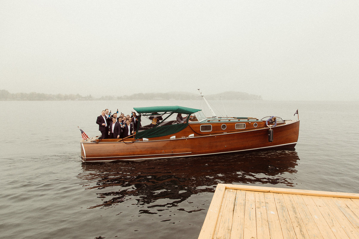 groomsmen on wooden boat at Antique Boat Museum wedding