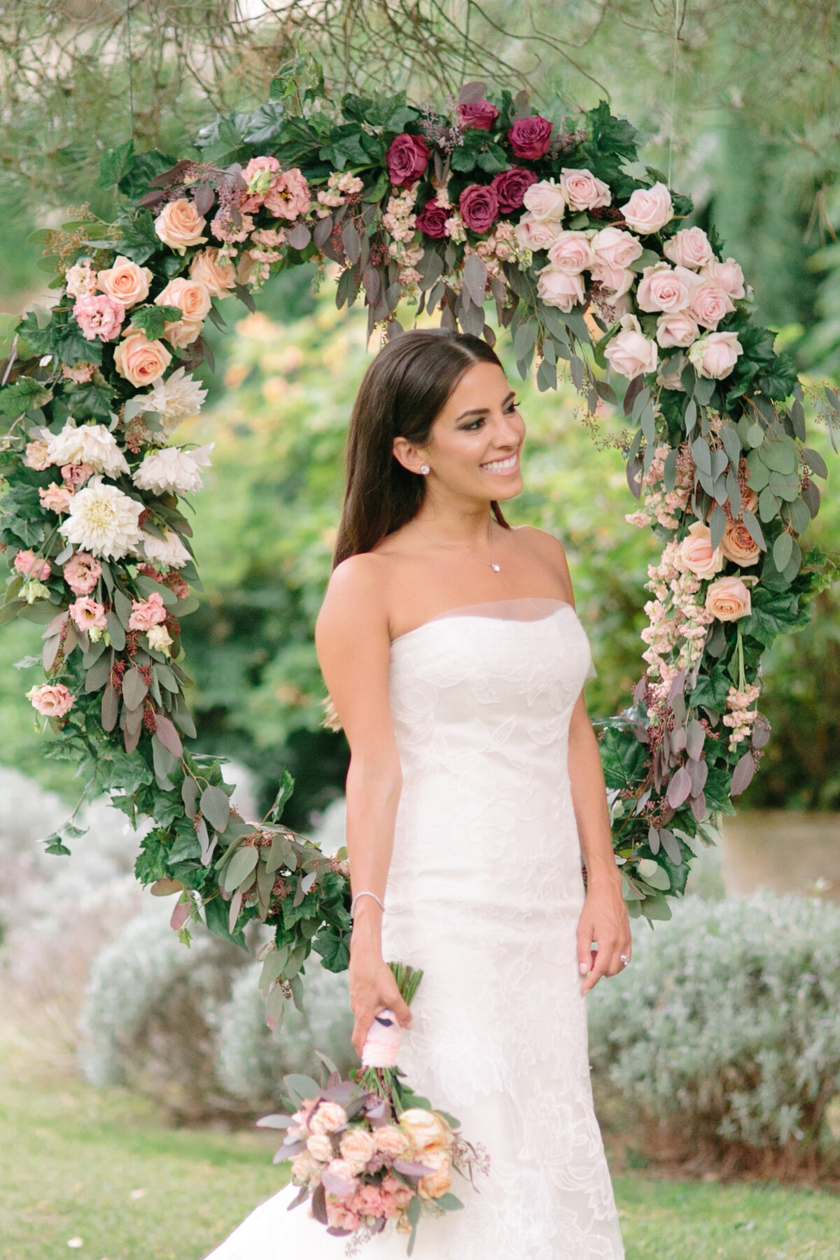 Stunning bride and rose-covered round arch