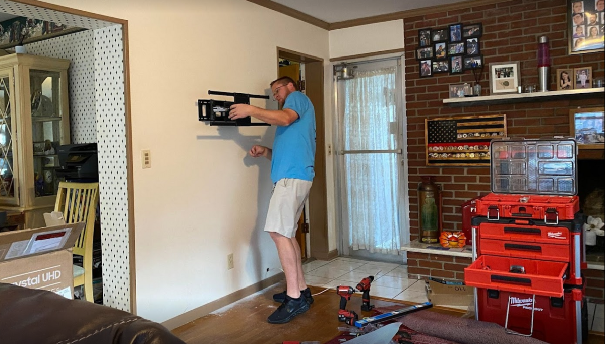 Chris at Suncoast Repairs mounting TV