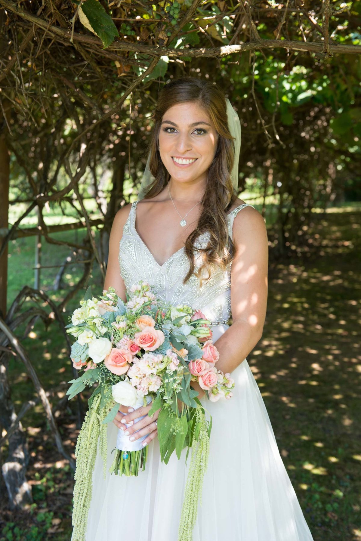 Bride smiling holding bouquet outside at Flowerfield