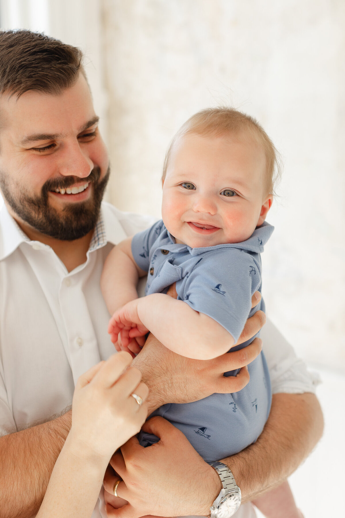 dad smiles at baby boy  during family photoshoot in boston