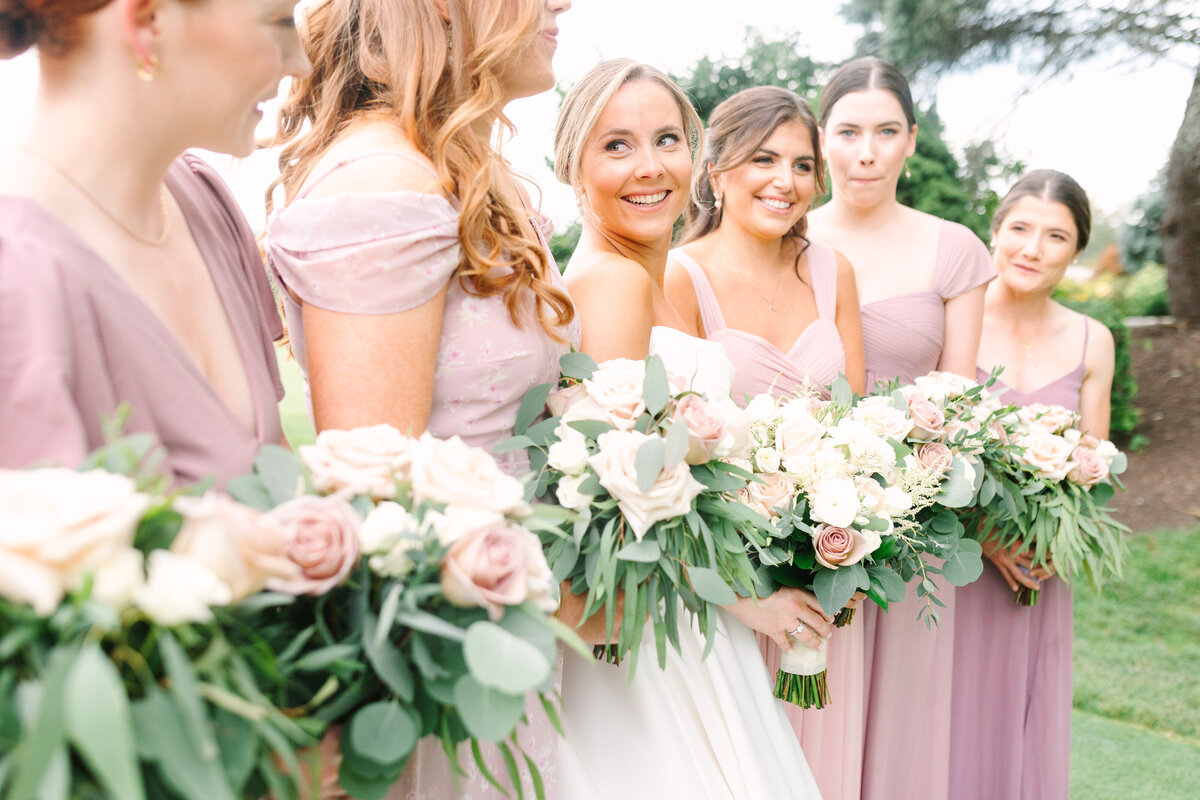 Bride and her bridesmaids pose for portrait with bouquets