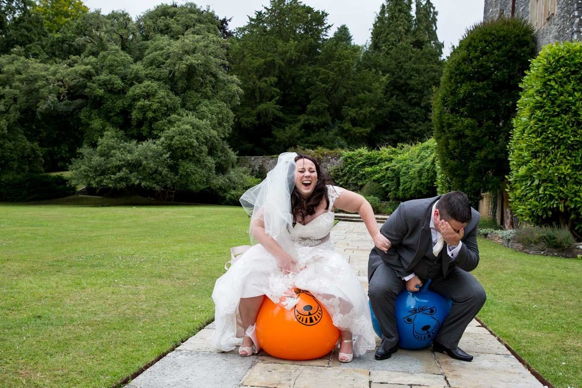 Bride and Groom on space hoppers at Dartington Hall Wedding