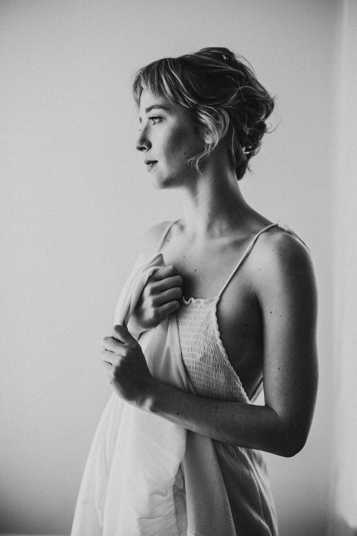 black and white image woman posing holding dress