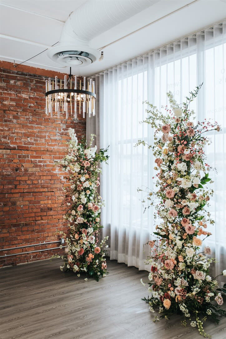 Beautiful and romantic ceremony floral installation featuring pink, peach and white hues, wedding planned by Fiore Fine Events, an elegant wedding planner based in Calgary, Alberta.  Featured on the Brontë Bride Vendor Guide.
