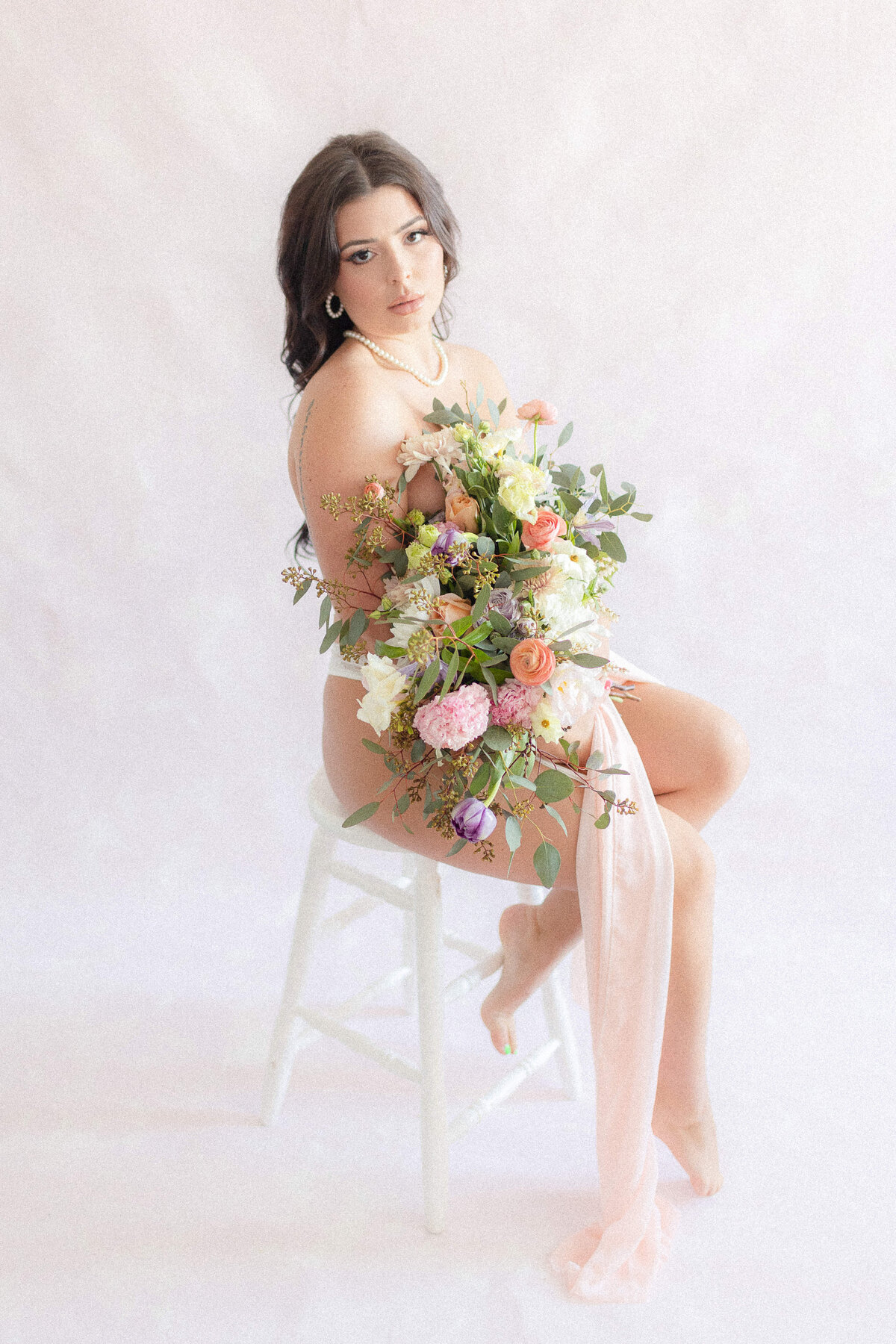 bridal sitting on stool holding bouquet
