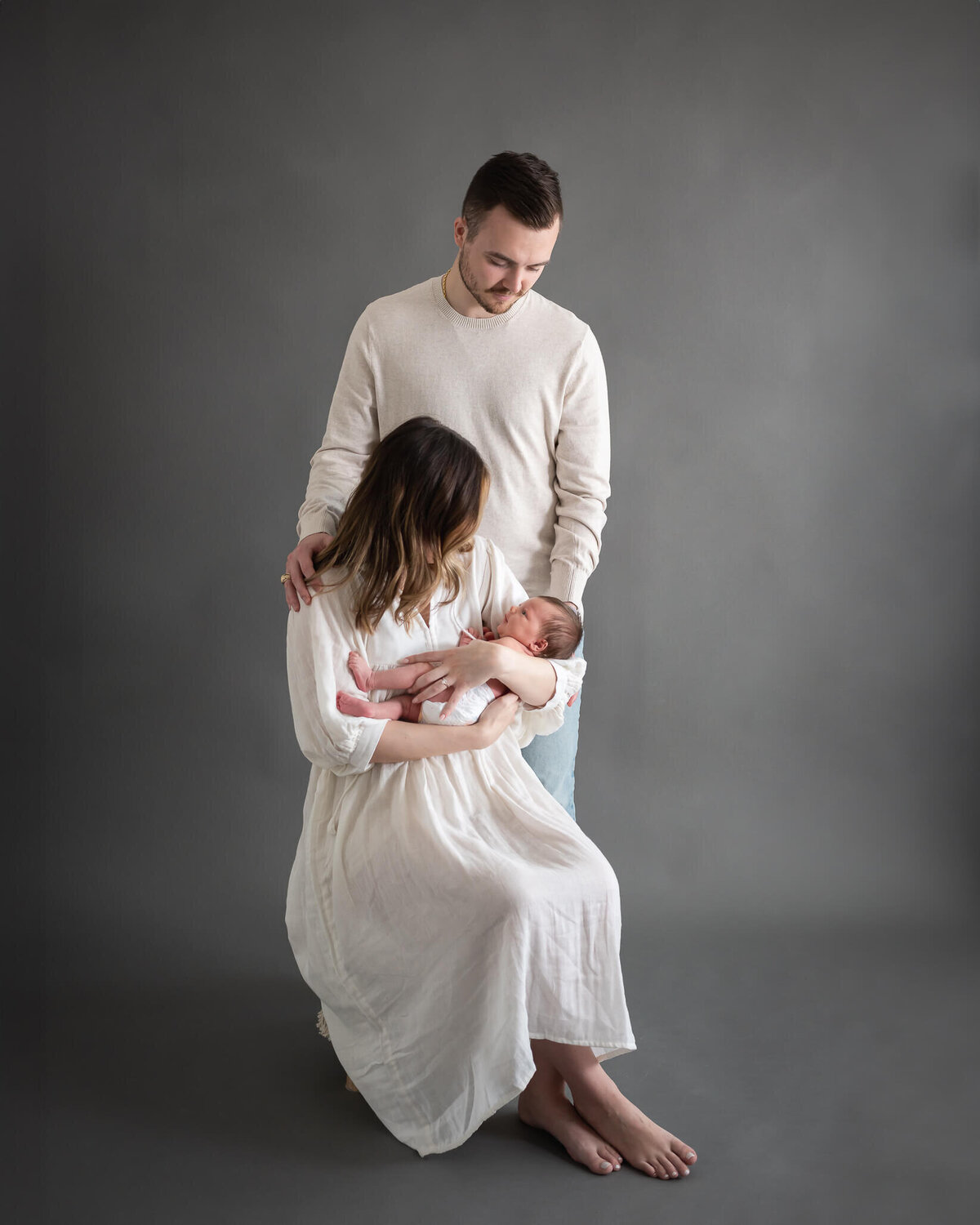 beautiful studio portrait of new parents with baby