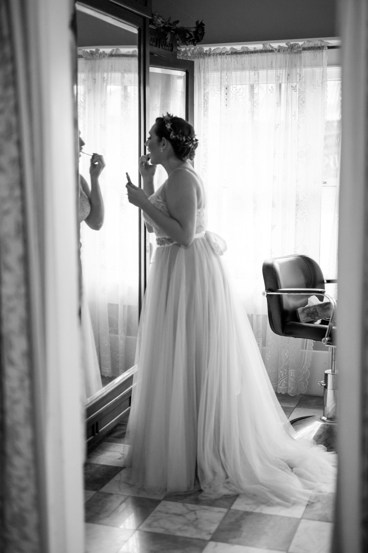 black and white portrait of bride putting make up on getting ready before ceremony at Spinelli's wedding venue Hill Country