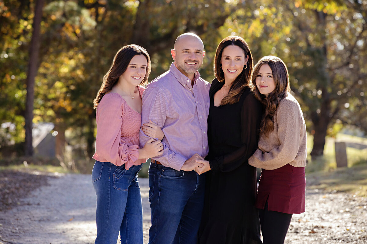 Cozy family hug on gravel path surrounded by colorful fall leaves at Anne Springs Close Greenway Charlotte NC